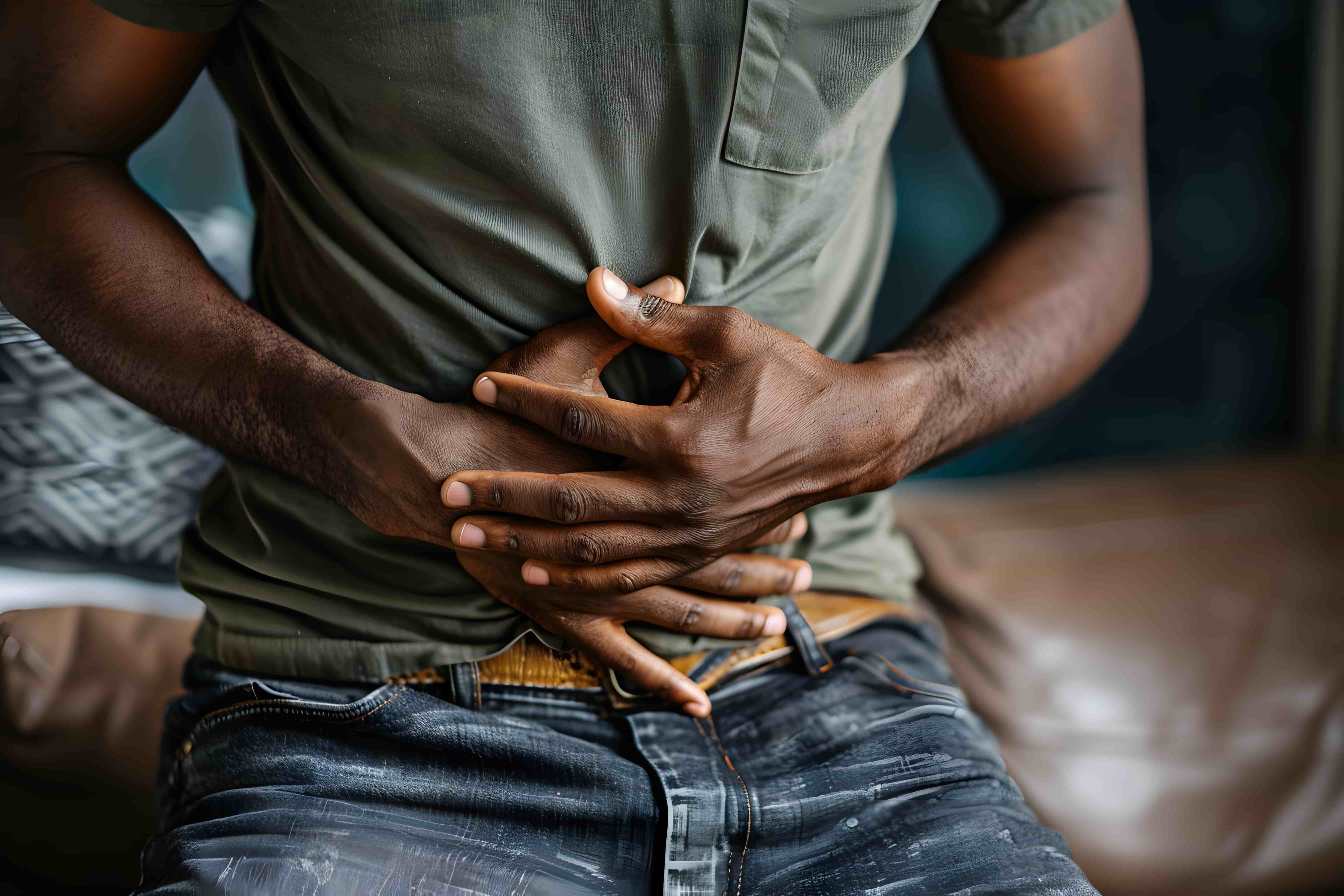 Man holding his stomach in pain experiencing severe abdominal cramps from Norovirus infection