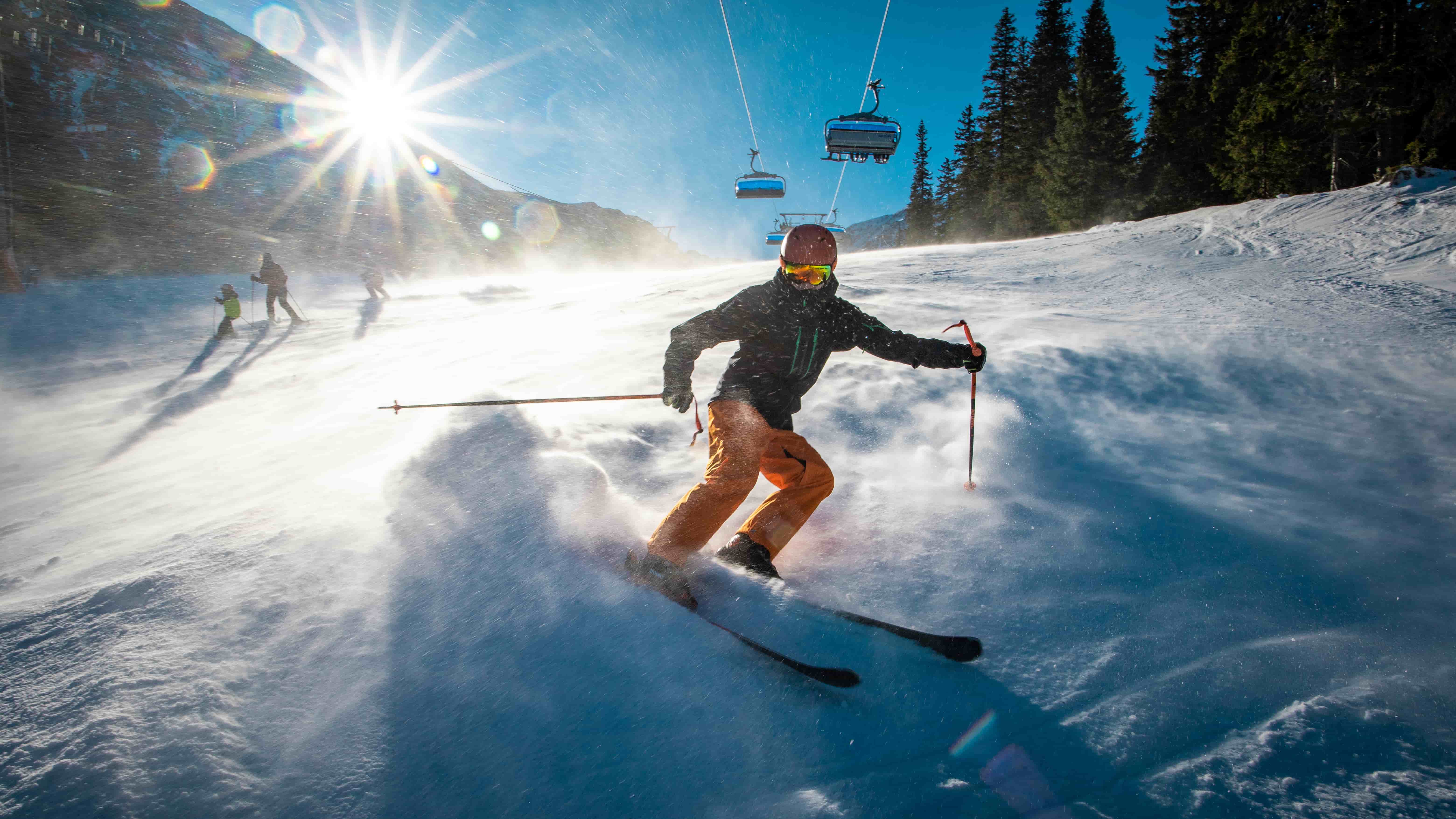 Skier on snowy mountain slope in Japan with bright sunlight reflecting off the snow