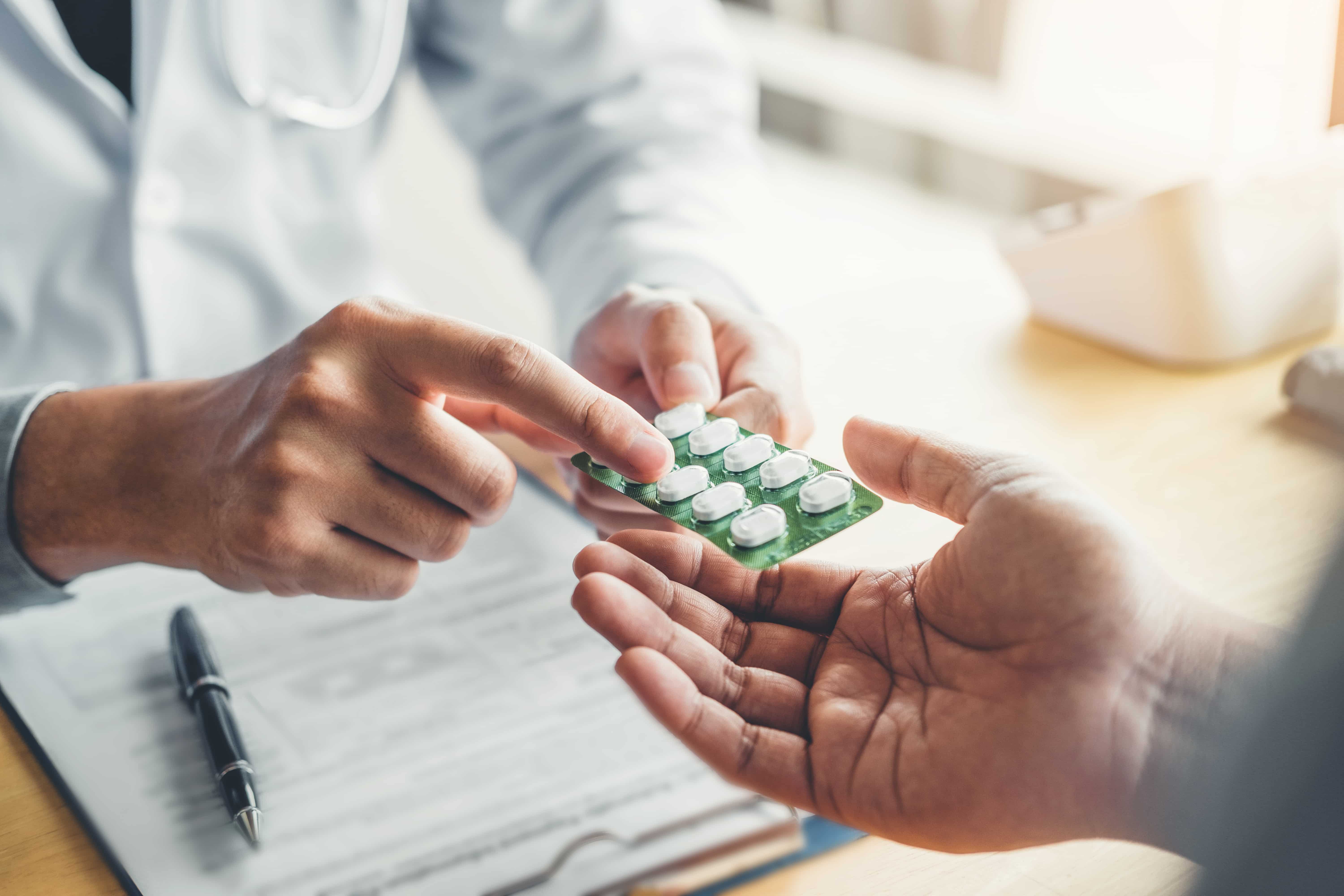 Man receiving prescription medication from pharmacy after online doctor consultation for UTI treatment